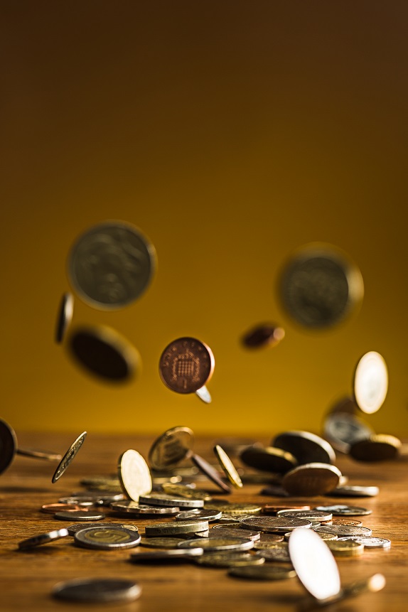 The silver and golden coins and falling coins on wooden table background