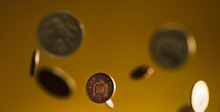 The silver and golden coins and falling coins on wooden table background