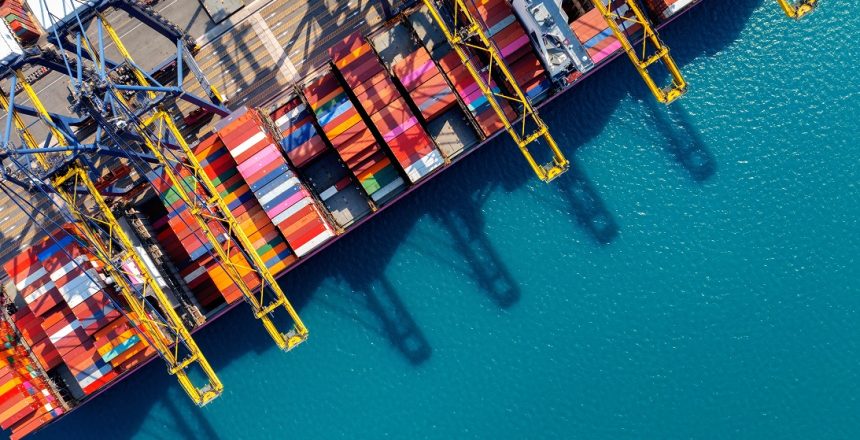Aerial view of cargo ship and cargo container in harbor.